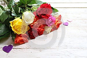 Colorful roses with hearts on white wooden boards