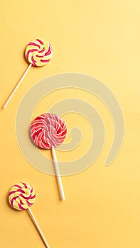 Colorful round lollipops on a yellow background. Festive background.