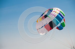 Colorful round parachute against the blue sky