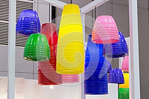 Colorful round stylish lampshades hang from ceiling