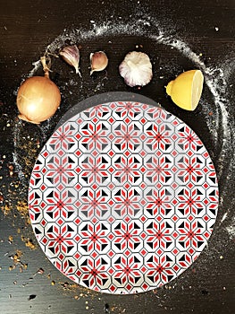 colorful round tray and various spices on the black table.