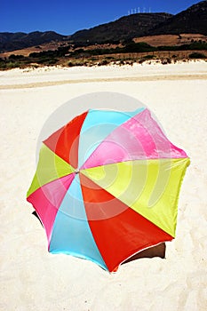 Colorful round umbrella on white sandy beach