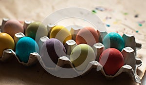 Colorful Row dyed Easter eggs in a carton on table