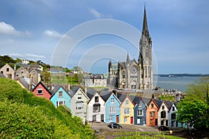 Colorful row houses with St. Colman`s Cathedral in background in the port town of Cobh, County Cork, Ireland