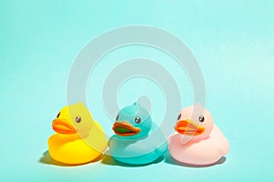 Colorful rubber bath ducks on blue background