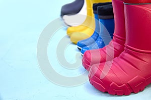 Vibrant Rubber Boots in Line on Blue Surface