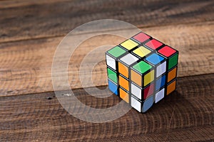 Colorful rubik`s cube on a wooden table background