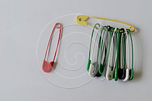 Colorful safety pins on white background.