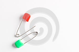 Colorful safety pins on white background, flat lay. Space for text