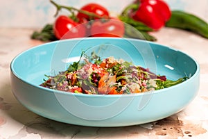 Colorful salad with pumpkin, lettuce, tomatoes, and quinoa on a blue plate