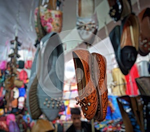 Colorful sandals hanging in the shop to attract the customer for sale.