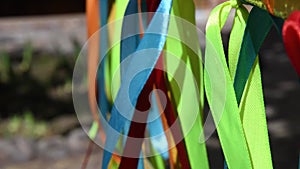 Colorful satin ribbons hang and swing in wind. Summer fun background