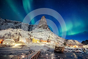 Colorful scandinavian village with northern lights over peak mountain at Lofoten