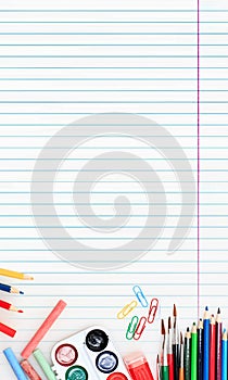 Colorful school supplies corner border over a lined paper background with negative space