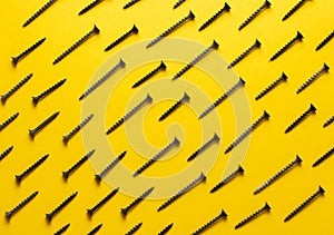 Colorful screw pattern top view on yellow background