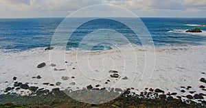 Colorful sea beach, waves foaming and splashing on the rocky shoreline. Ocean waves in open sea at Tenerife north, Anaga