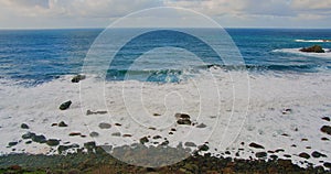 Colorful sea beach, waves foaming and splashing on the rocky shoreline. Ocean waves in open sea at Tenerife north, Anaga