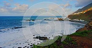 Colorful sea beach, waves foaming and splashing on the rocky shoreline. Ocean waves in open sea at Tenerife north, Anaga