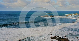 Colorful sea beach, waves foaming and splashing on the rocky shoreline. Ocean waves in open sea at Tenerife north, Anaga