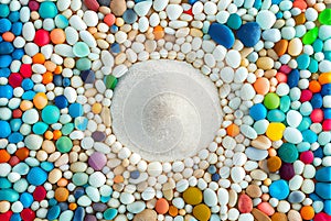 Colorful sea pebbles round frame with beach white sand copy space