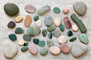 Colorful sea stones composition on gray background close up