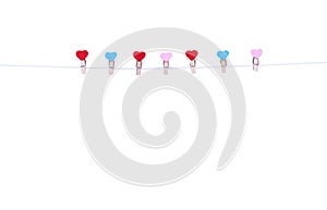 Colorful seven wood clothes pins in heart shape patterns hanging on white string isolated on white background , clipping path