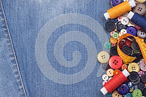 Colorful sewing buttons, yellow measuring tape and thread spools