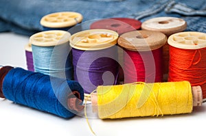 Colorful sewing thread spool bobbins on white background