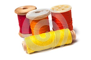 Colorful sewing thread spool bobbins on white background