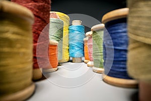 between colorful sewing thread spools