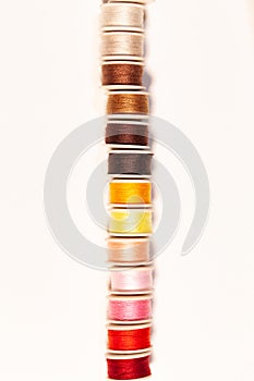 colorful sewing threads on bobbins isolated on white