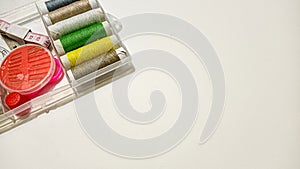 Colorful Sewing Tools and Threads Arranged on a Clean White Workspace