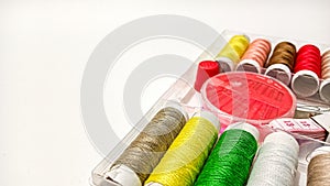 Colorful Sewing Tools and Threads Arranged on a Clean White Workspace