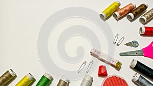 Colorful Sewing Tools and Threads Arranged on a Clean White Workspace