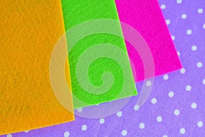 Colorful sheets of felt on purple background