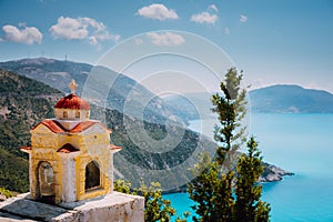 Colorful shrine Proskinitari on pedestal. Amazing sea view to Greece coastline in the background