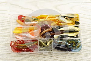 Colorful silicone fishing baits with plummets on wooden table. Toned image and top view