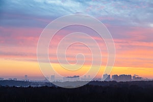 Colorful sky over city and park at cold dawn