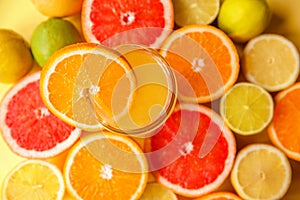 Colorful sliced citrus - oranges, grapefruits, lemons and limes close-up around a glass of orange juice and a slice of photo