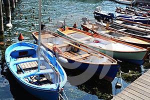 Colorful small boats and ducks in touristic port of Sulzano, Italy