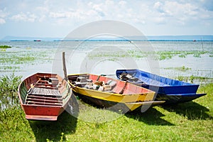 Colorful small fishing boats with anchor stones to stabilize and photo