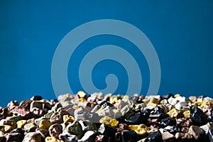 Colorful small sea stones texture on blue background