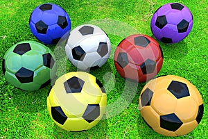 Colorful soccer balls on grass