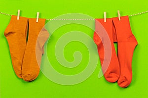 Colorful   socks hanging on a rope on green   background - Image