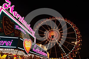 Colorful souvenir shop over a background of a Ferris wheel at Octoberfest, Munich, Germany