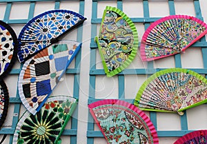 Colorful Spanish handmade fans attached to a blue wooden construction