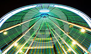 The colorful spinning ferris wheel in the night