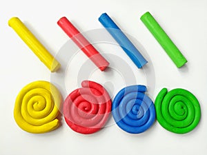 Colorful spiral plasticine, multicolored sticks clay dough, white background