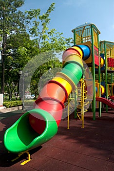Colorful spiral tube slide at public playground .