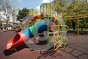 Colorful spiral tube slide at public playground .